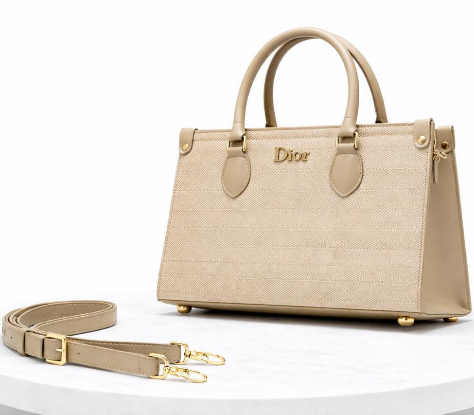 Beige handbag with gold accents on a white background
